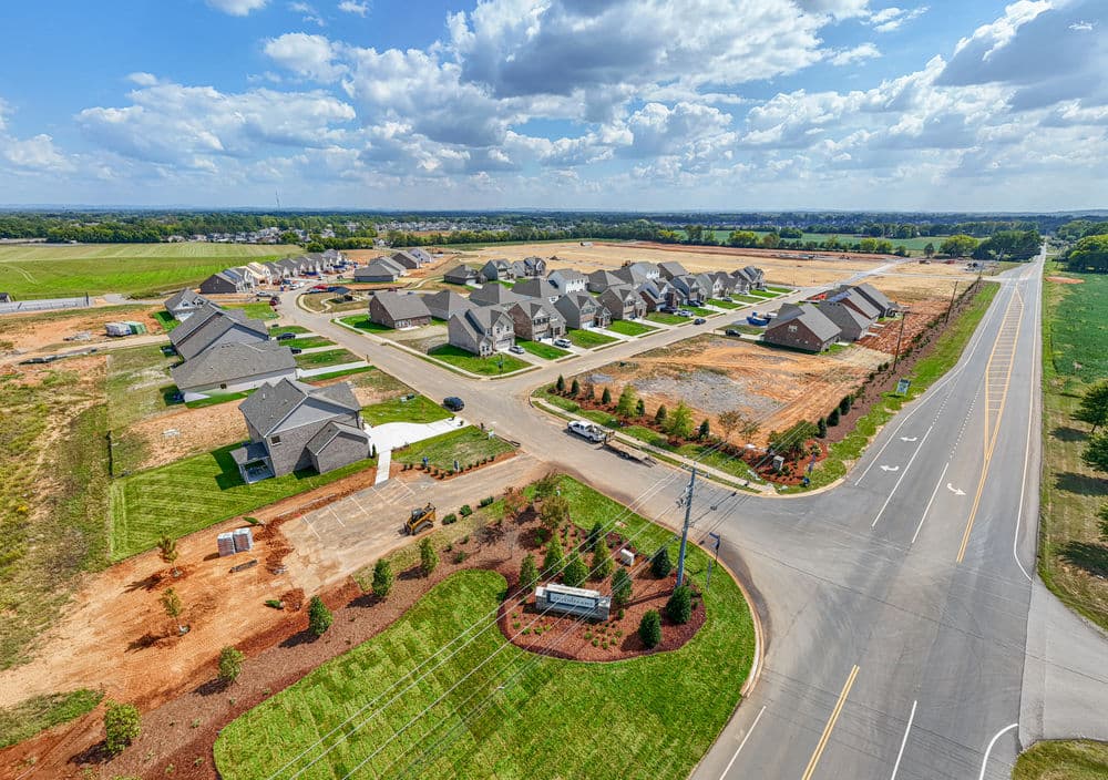Aerial view of a new residential neighborhood with houses and wide open fields.